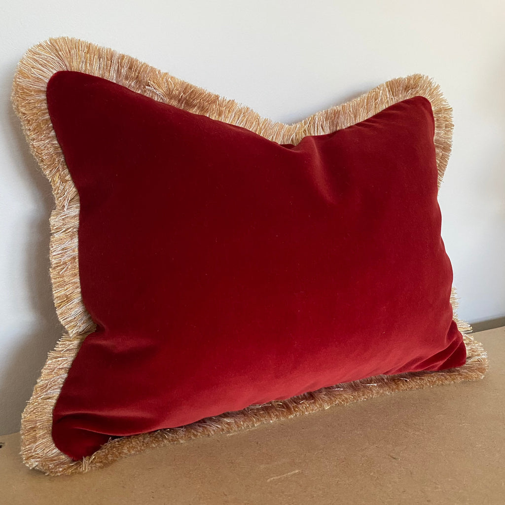 red designer velvet cushion with gold fringe trim